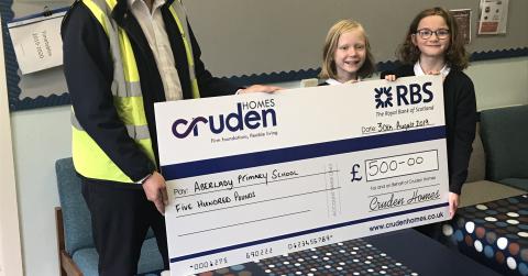 Andy Brown, Contracts Manager for Meadowside, Aberlady, presenting the cheque to two pupils at Aberlady Primary school